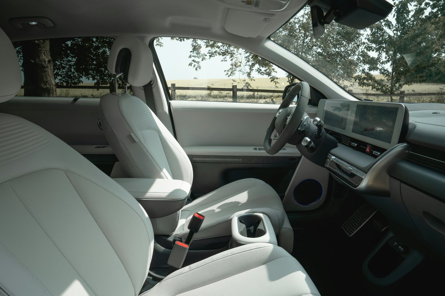 Minimalist electric car interior overlooking a rural landscape.