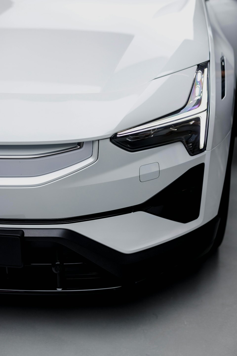 White electric car featuring sleek LED headlights and bumper.